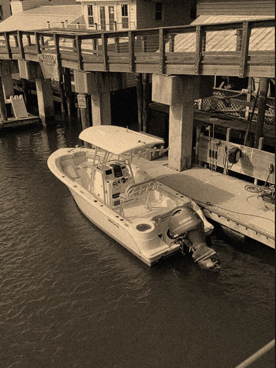 A center-console rental boat tied at the Shem Creek dock
