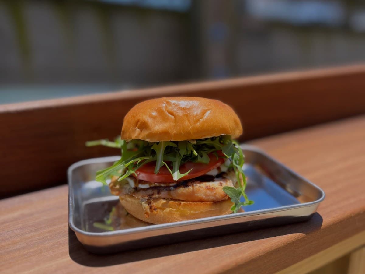 Burger on a steel tray at the Outpost counter