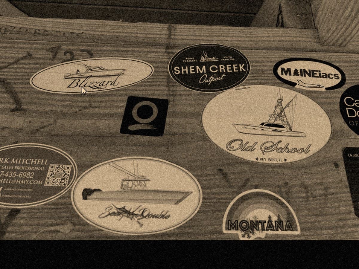 Shem Creek stickers and badges on weathered wood